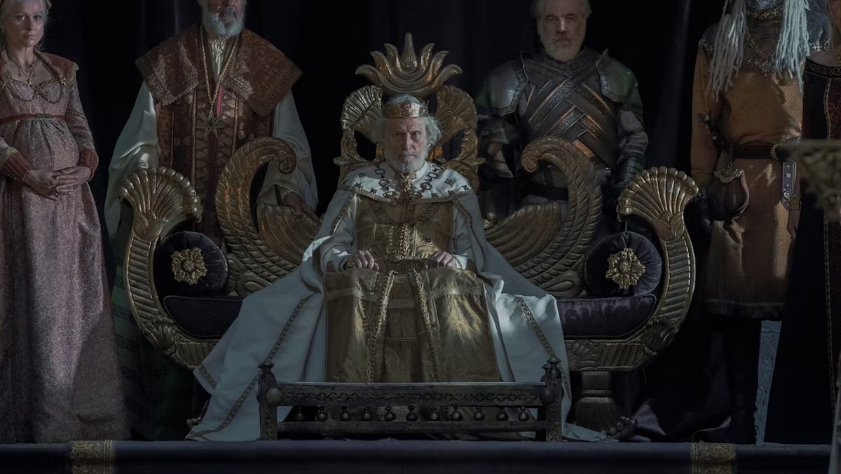 King Jaehaerys on a throne surrounded by his family and guards on House of the Dragon